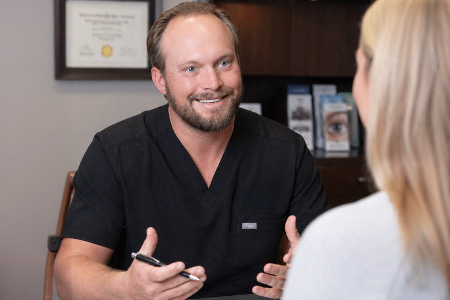 Dr. Ray discussing lower eyelid blepharoplasty with a patient during an in-office consultation, explaining treatment options and expected results.