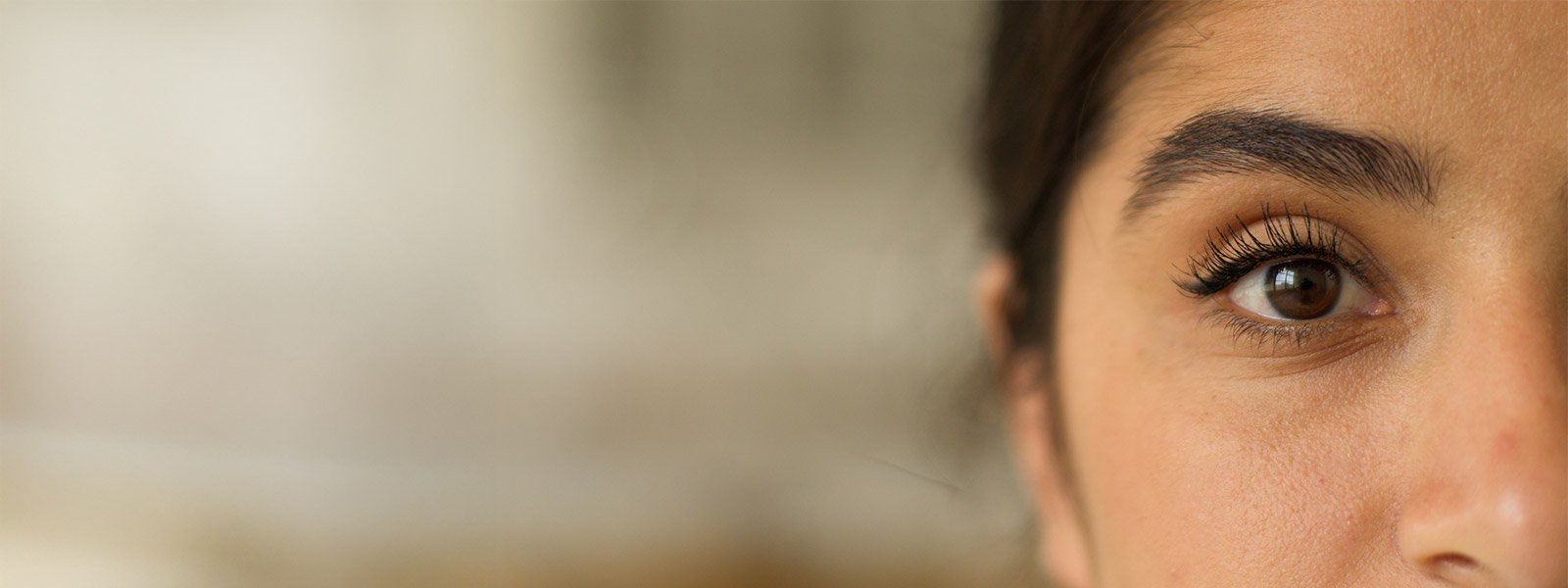 Dark eye Indian Arabian woman cropped view healthy girl female look gaze health medicine clinic laser correction ophthalmology looking at camera eyesight make-up indoor.