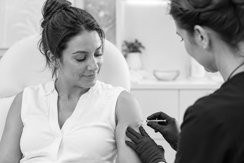 Patient receiving a provider-guided weight loss injection in a calm, modern wellness clinic setting.