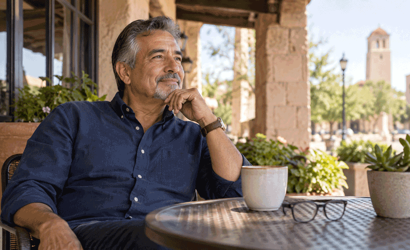 man enjoying an outdoor café while considering whether refractive lens exchange is covered by insurance.