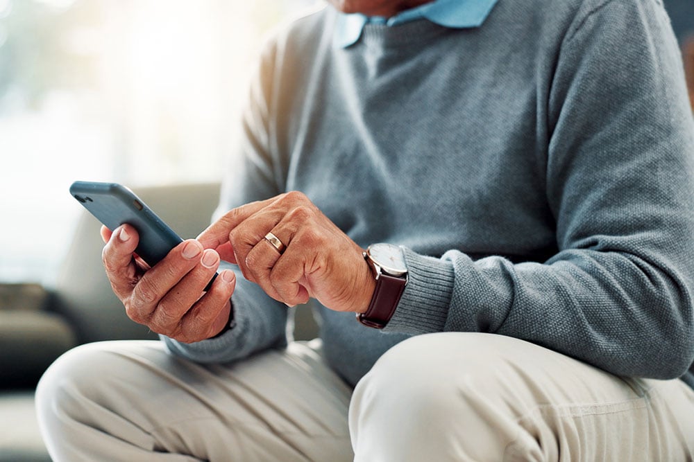 A patient uses a smartphone to complete mobile check-in before their eye care appointment at West Texas Eye Associates.